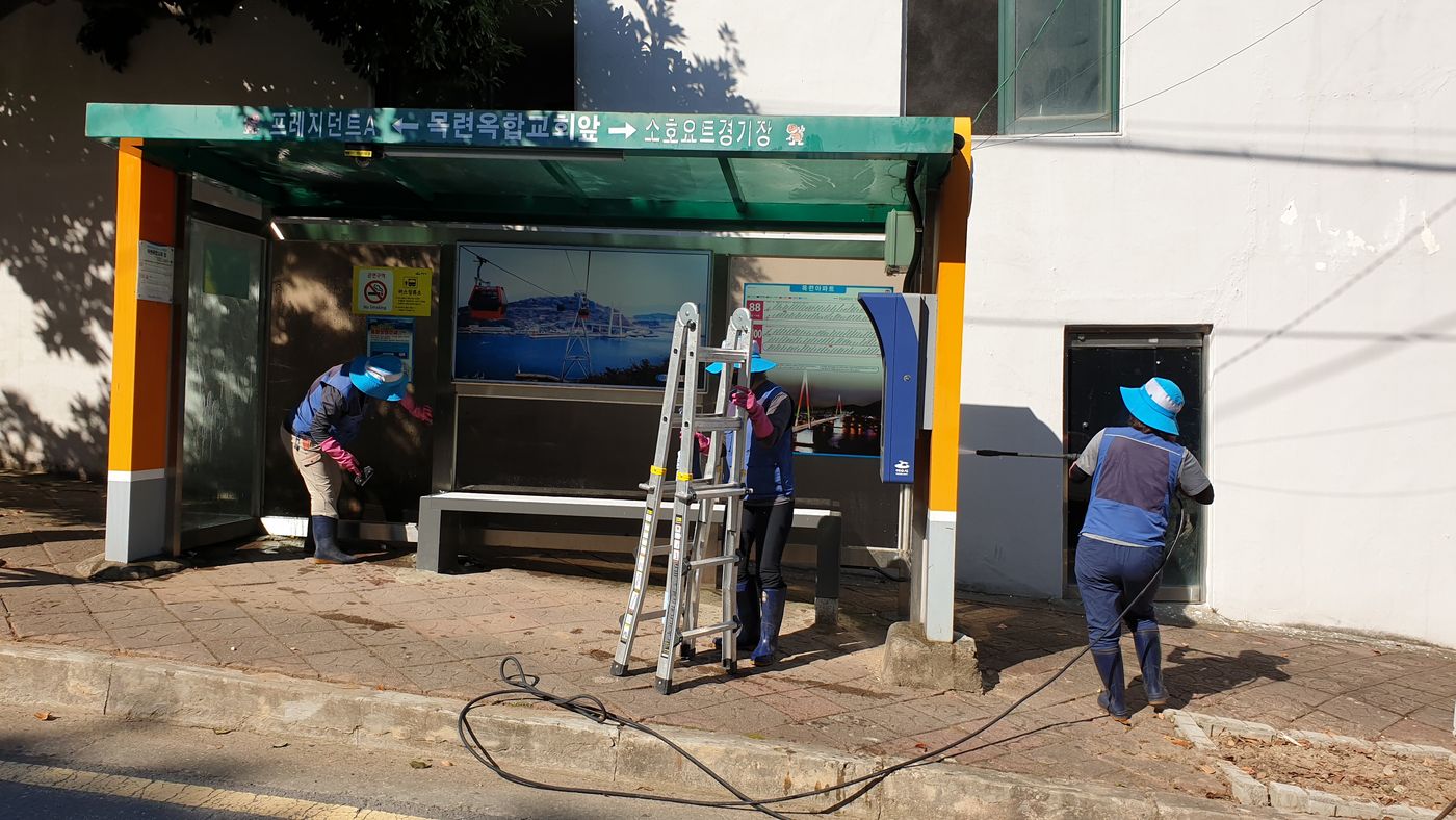 버스 승강장 정비 — 승강장 의자와 주변을 정리하는 모습